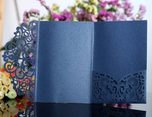 Macro shot of navy blue laser-cut wedding invitation cover with pearl paper texture