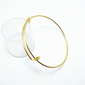 Detailed view of glossy gold adjustable wire bangle with a smooth expandable mechanism
