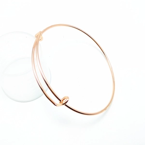 Detail showing the adjustable rose gold bangle with a smooth polished finish and sliding knots