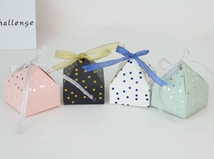 Detail view of four-color pyramid gift boxes with metallic gold polka dots and organza ribbons