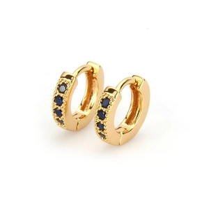 Detailed macro view of 18k gold plated huggie earrings featuring four blue zircon stones
