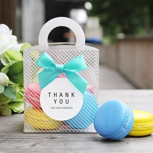 Transparent PVC gift box with Tiffany blue ribbon bow and thank you tag on wooden table