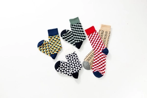 Flat lay of five pairs of colorful cotton socks with geometric and mustache patterns