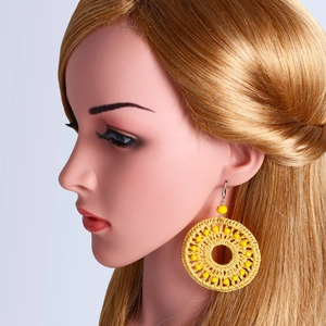 Bohemian style yellow handwoven beaded hoop earrings displayed on a fashion model mannequin