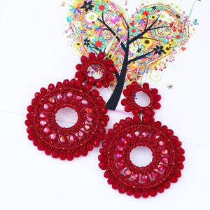 Detail view of handmade red bead double hoop earrings with woven crystal texture