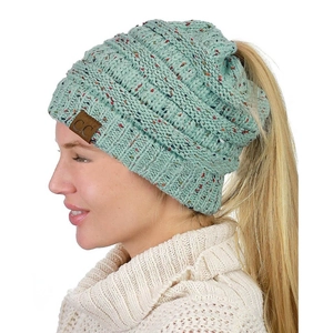 Detail of mint green knit beanie with ponytail hole and brown leather C.C tag