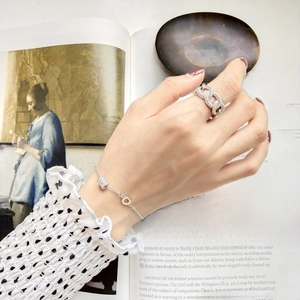Detailed view of silver chain link ring and beaded bracelet on an art book background