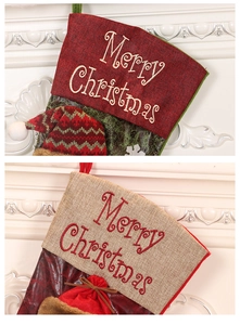 Détail de chaussettes de Noël en lin rouge et beige avec broderie Merry Christmas