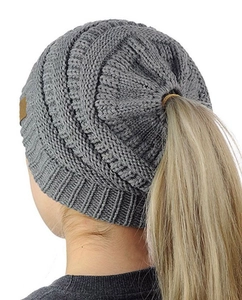 Detail view of grey knit beanie featuring a functional ponytail hole for long hair