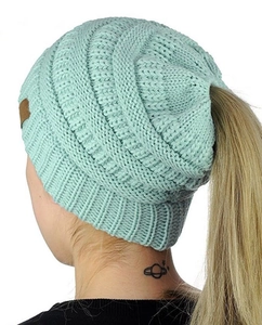 Detail of mint green cable knit open top hat showing ponytail hole and leather patch