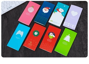 Detailed flat lay of eight colorful 3D wing heart Christmas cards on wood background