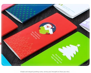 Close-up of 3D pop-up Christmas cards with Santa and tree motifs on wooden background