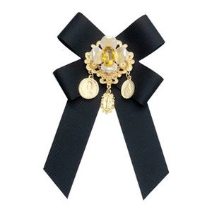 Detailed macro view of vintage black ribbon bow brooch with gold coins and pearl inlay