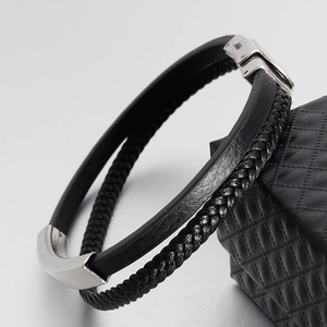 Close-up of double-layer black leather and braided bracelet with silver metal snap buckle