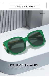 Detail of square green translucent sunglasses with gold metal hinges on display