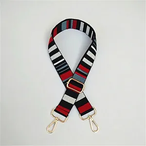 Detail of adjustable colorful woven bag strap with gold metal buckle and lobster clasp