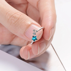 Sparkling silver star ring with blue rhinestone and small crystals on a silver band