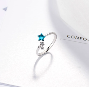 Close-up of adjustable silver ring featuring blue crystal star and pavé zircon details