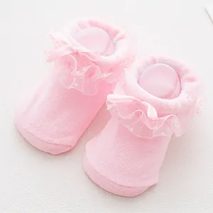 Detail of pink cotton baby socks featuring delicate lace edges and a soft silk bow accent