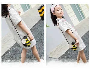 Kid bee crossbody bag shown on child model in outdoor street setting for size reference