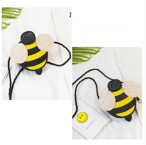 Detail of creative bee-shaped kids crossbody bag with yellow and black stripes