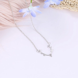 Close-up of minimalist silver reindeer antler pendant necklace with delicate chain