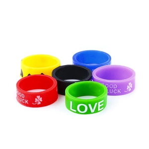 Close-up of flexible silicone rings featuring LOVE and GOOD LUCK embossed lettering