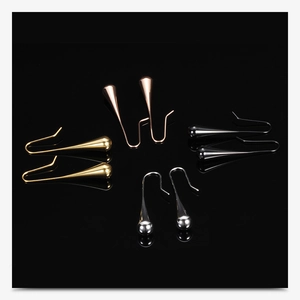 Macro detail of tear-drop earrings in gold, silver, rose gold, and black mirror finish