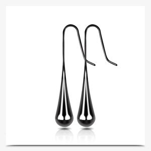 Detailed view of long black teardrop earrings with high-gloss finish and mirror reflection