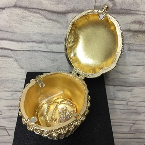 Detail view of gold cupcake clutch bag interior with chain strap and crystal rhinestones