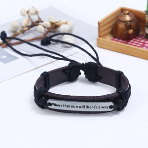 Détail d'un bracelet en cuir tressé avec plaque gravée 'Where there's a will there's a way'