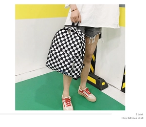 Foto de estilo callejero de una mochila de nailon a cuadros blancos y negros con modelo