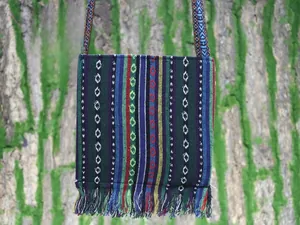 Detailed shot of ethnic woven crossbody bag with colorful stripes and fringe tassels