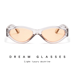 Close-up of cat-eye sunglasses with transparent frames and orange lenses on white background