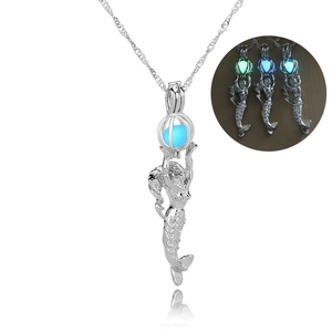 Silver mermaid cage necklace with glowing bead charms in green, blue, and cyan light