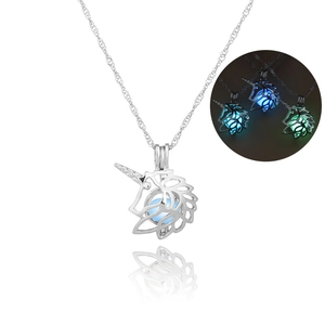 Detailed view of unicorn pendant with luminous beads glowing in blue and green