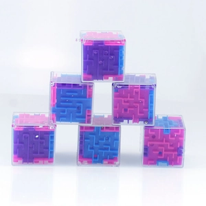 Close-up of 3D maze cubes with colorful internal tracks and metal ball for brain training