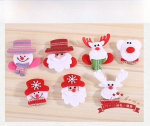 Detail of Christmas felt pins featuring Santa and reindeer on a wooden background