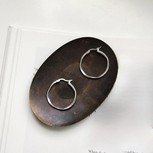 Macro detail of S925 sterling silver Mobius hoop earrings with a matte brushed finish