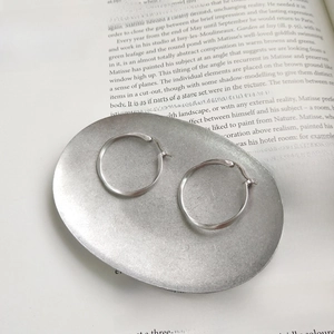 Detail shot of 925 sterling silver hoop earrings with S925 hallmark on a metal tray