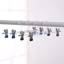 Detail of stainless steel clothes pegs with protective tips on a drying rack hanger