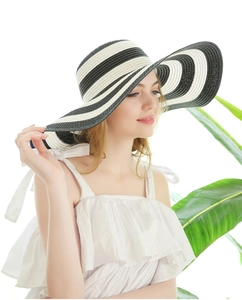 Detail of wide brim straw sun hat with black and white stripes for summer vacation