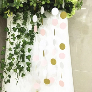 Close-up of white, pink, and gold glitter paper circle garland hanging for party decor