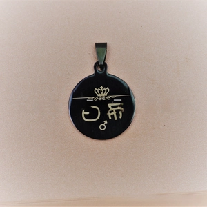Macro detail of black stainless steel round tag with gold crown and Mars symbol engraving