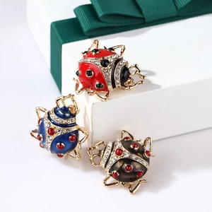 Three colorful enamel ladybug brooches with rhinestones on gift box and green ribbon