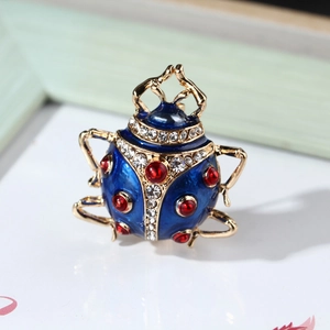 Macro shot of blue enamel ladybug brooch with sparkling red and clear crystal accents