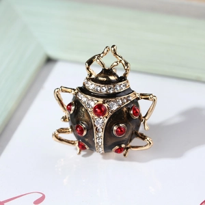 Macro view of ladybug beetle brooch with black enamel, red gems, and crystals