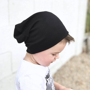 Close-up of a child wearing a black cotton slouchy beanie with soft knitted texture
