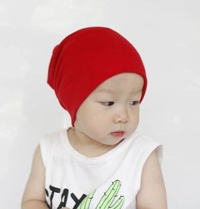 Close-up of a red cotton knit beanie worn by a baby for soft autumn winter warmth