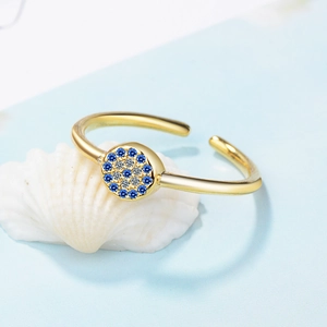 Gold open ring with Turkish evil eye blue zircon circle on white seashell background